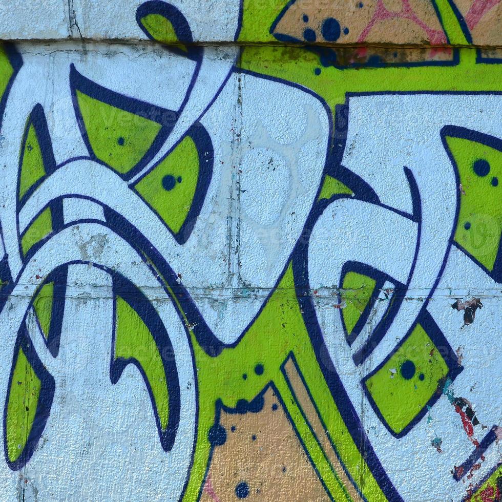 Fragment of graffiti drawings. The old wall decorated with paint stains in the style of street art culture. Colored background texture in green tones photo