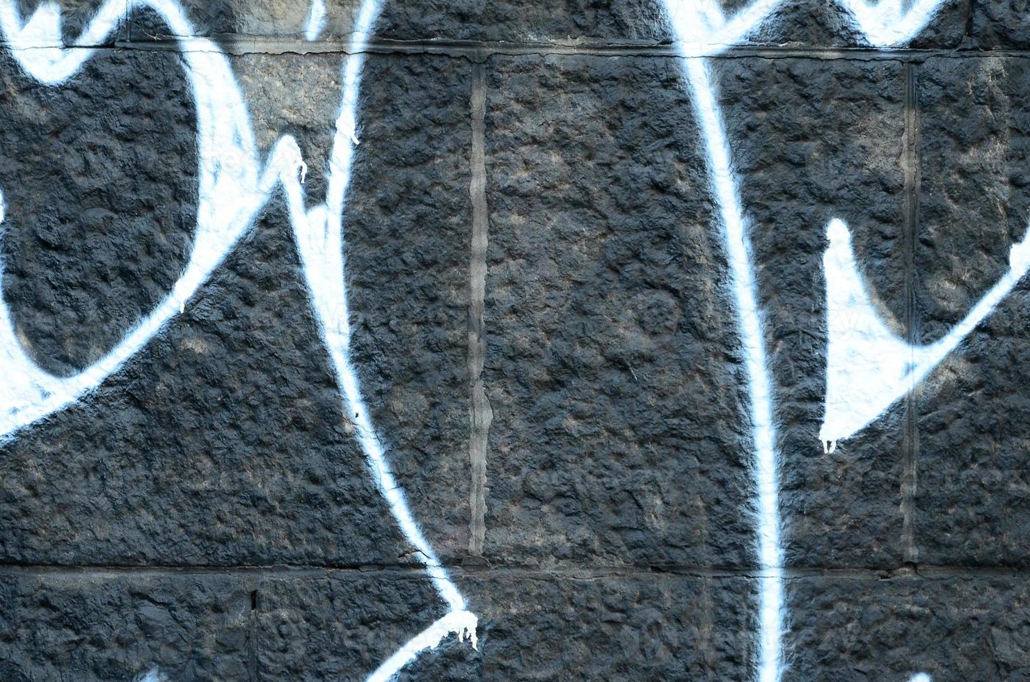 Fragment of graffiti drawings. The old wall decorated with paint stains in the style of street art culture. Colored background texture photo