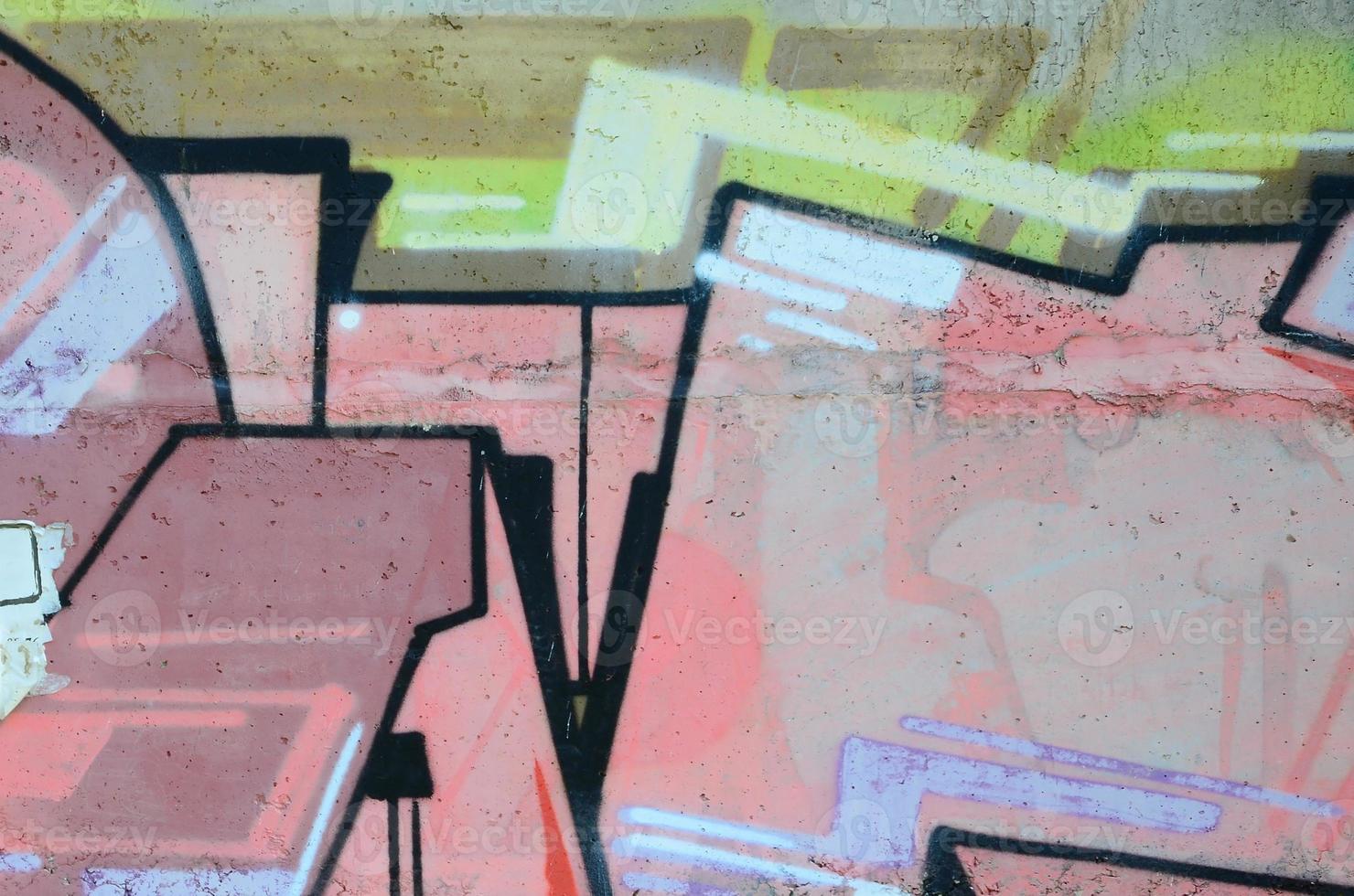 Fragment of graffiti drawings. The old wall decorated with paint stains in the style of street art culture. Colored background texture in warm tones photo