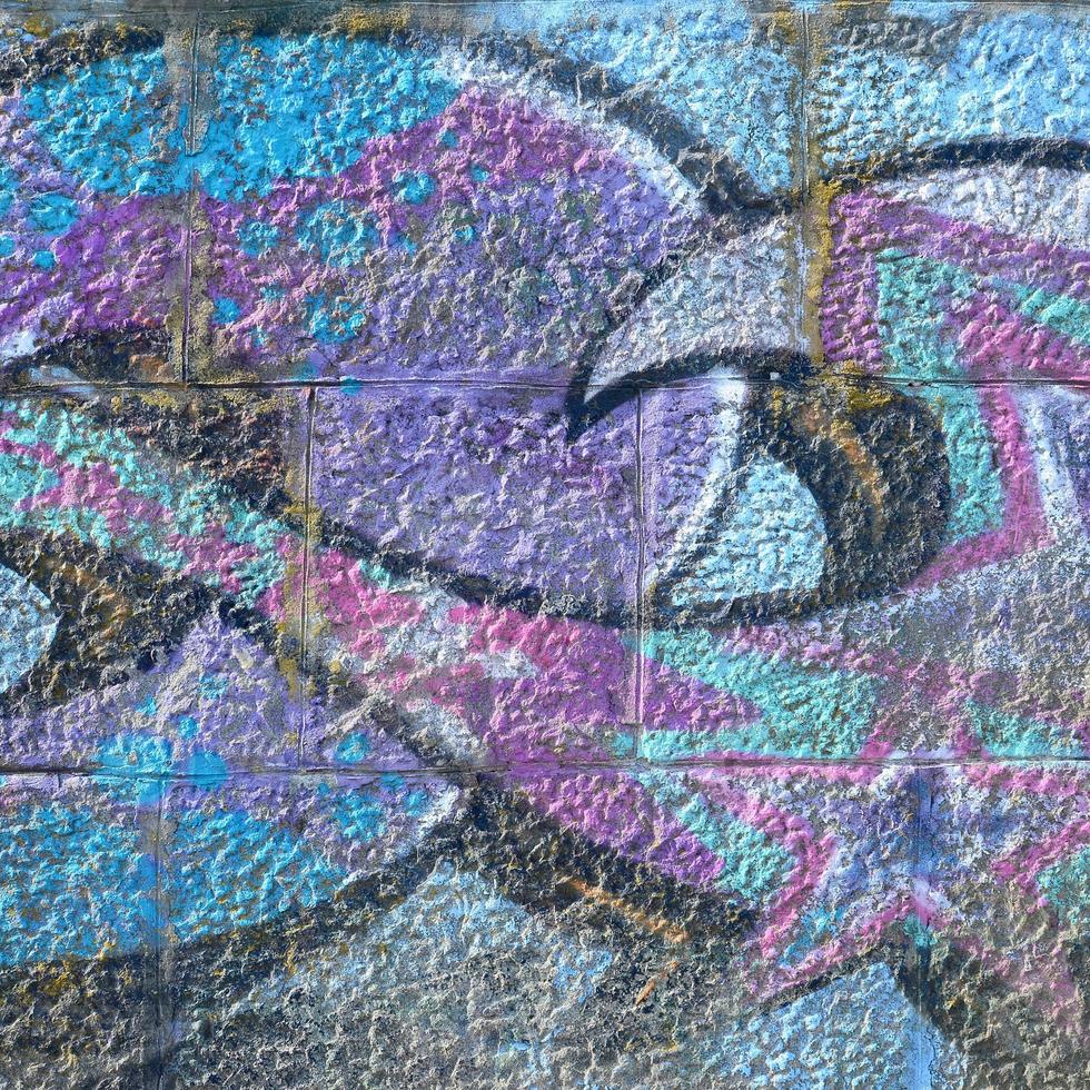 Fragment of graffiti drawings. The old wall decorated with paint stains in the style of street art culture. Colored background texture in purple tones photo