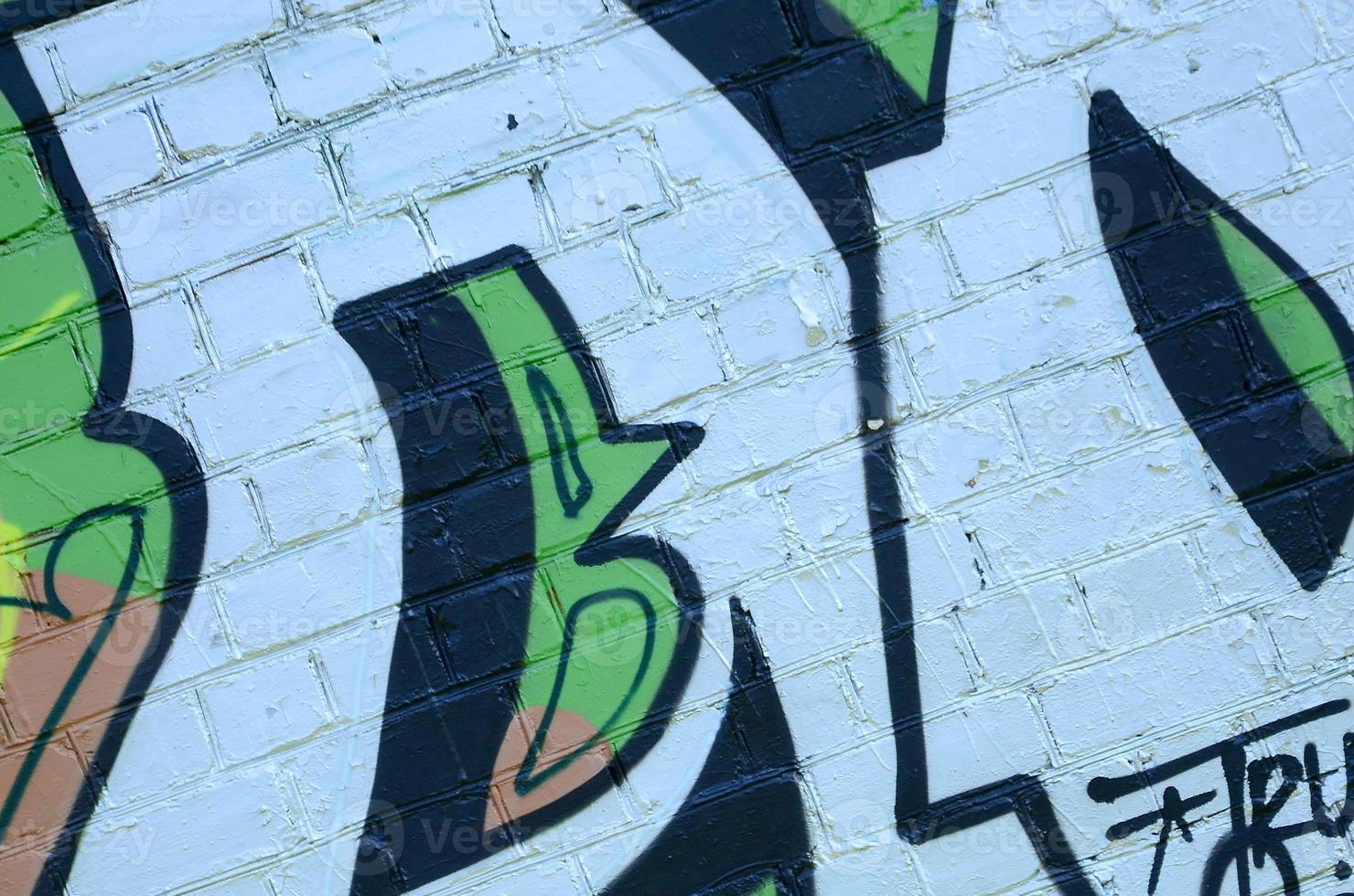 Fragment of graffiti drawings. The old wall decorated with paint stains in the style of street art culture. Colored background texture in green tones photo