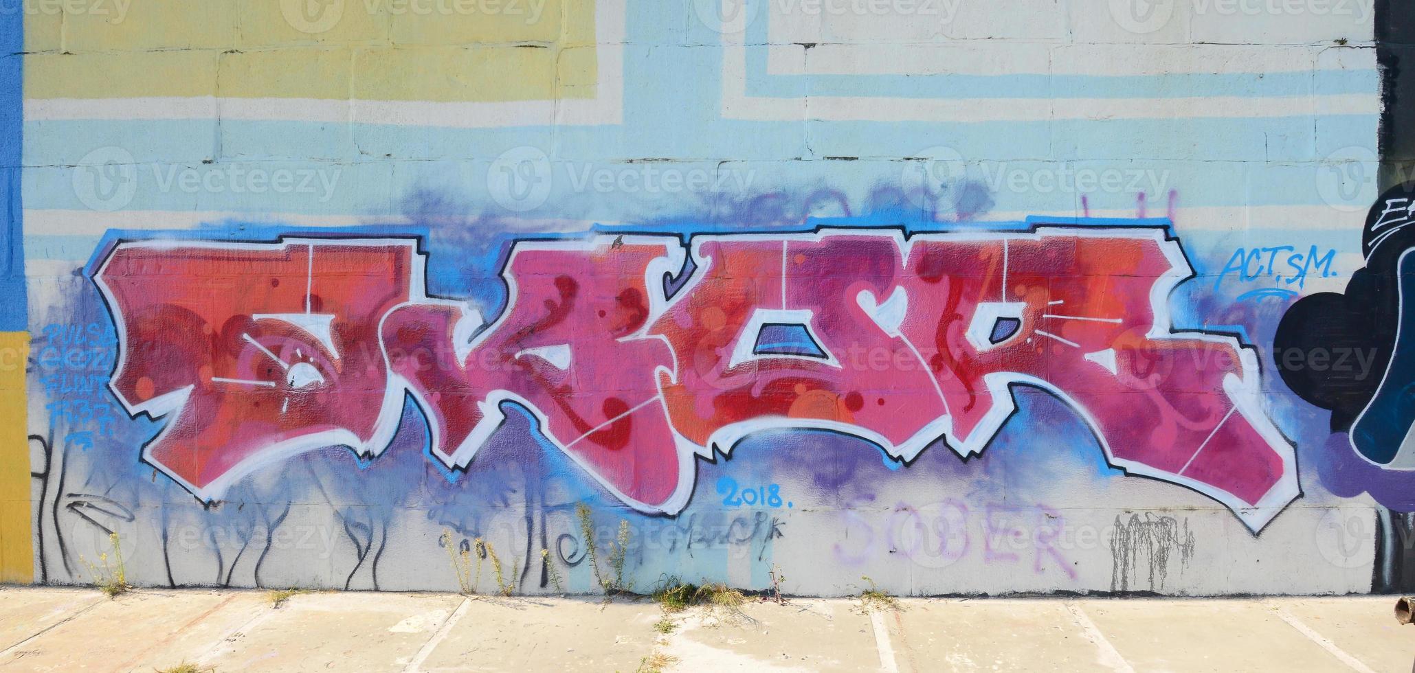Fragment of graffiti drawings. The old wall decorated with paint stains in the style of street art culture. Colored background texture in purple tones photo