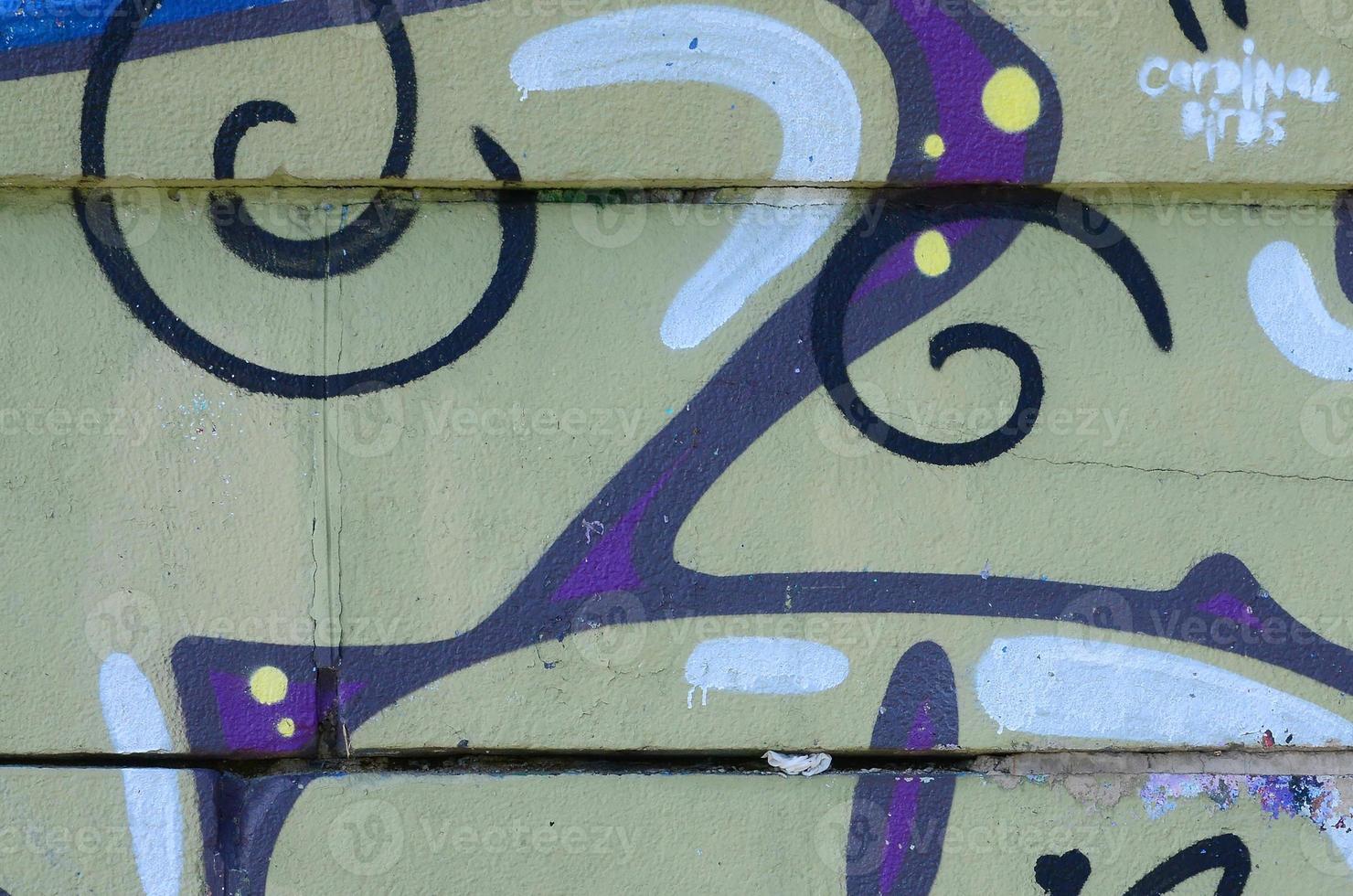 Fragment of graffiti drawings. The old wall decorated with paint stains in the style of street art culture. Colored background texture in warm tones photo