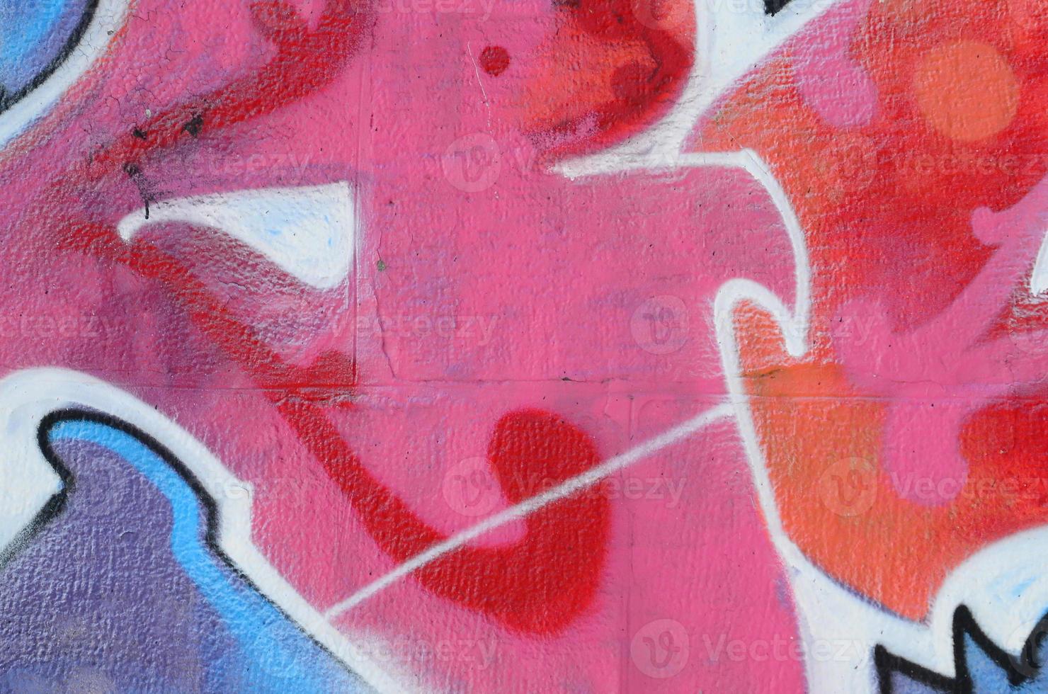 Fragment of graffiti drawings. The old wall decorated with paint stains in the style of street art culture. Colored background texture in warm tones photo