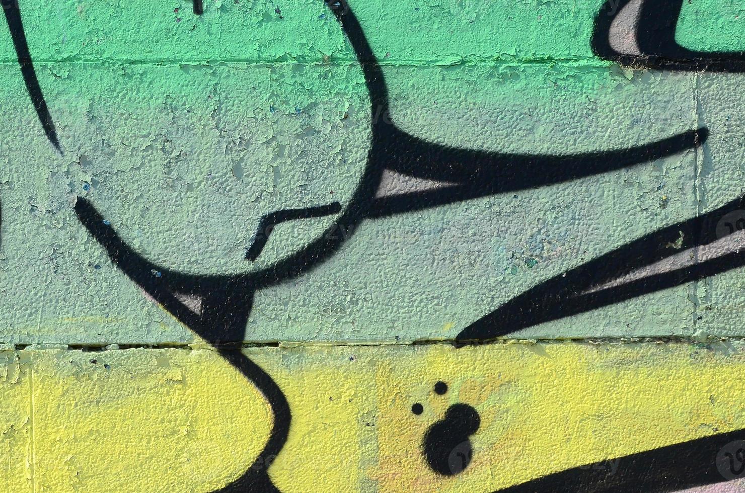 Fragment of graffiti drawings. The old wall decorated with paint stains in the style of street art culture. Colored background texture in green tones photo