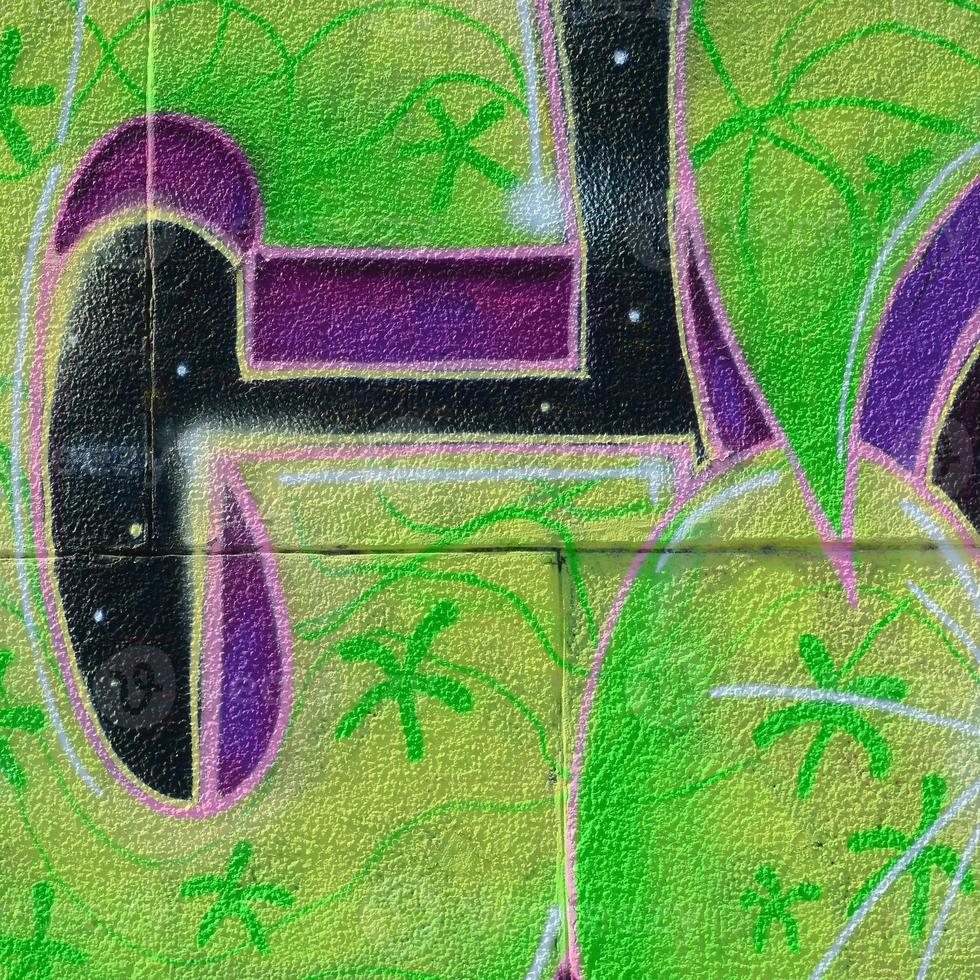 Fragment of graffiti drawings. The old wall decorated with paint stains in the style of street art culture. Colored background texture in green tones photo