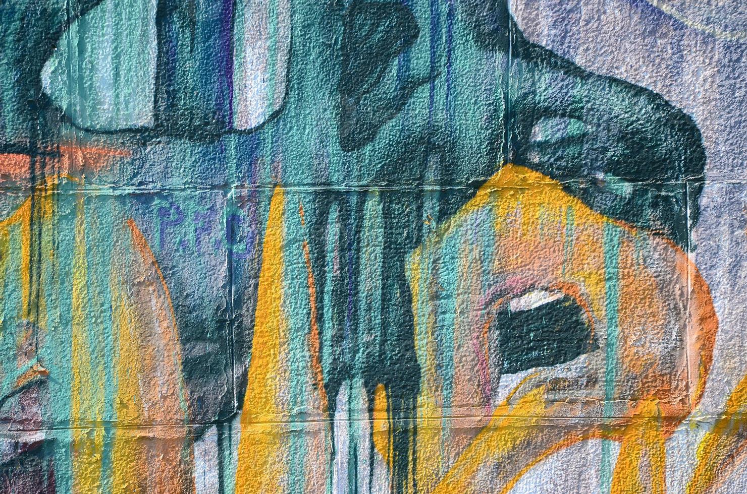 Fragment of graffiti drawings. The old wall decorated with paint stains in the style of street art culture. Colored background texture in warm tones photo