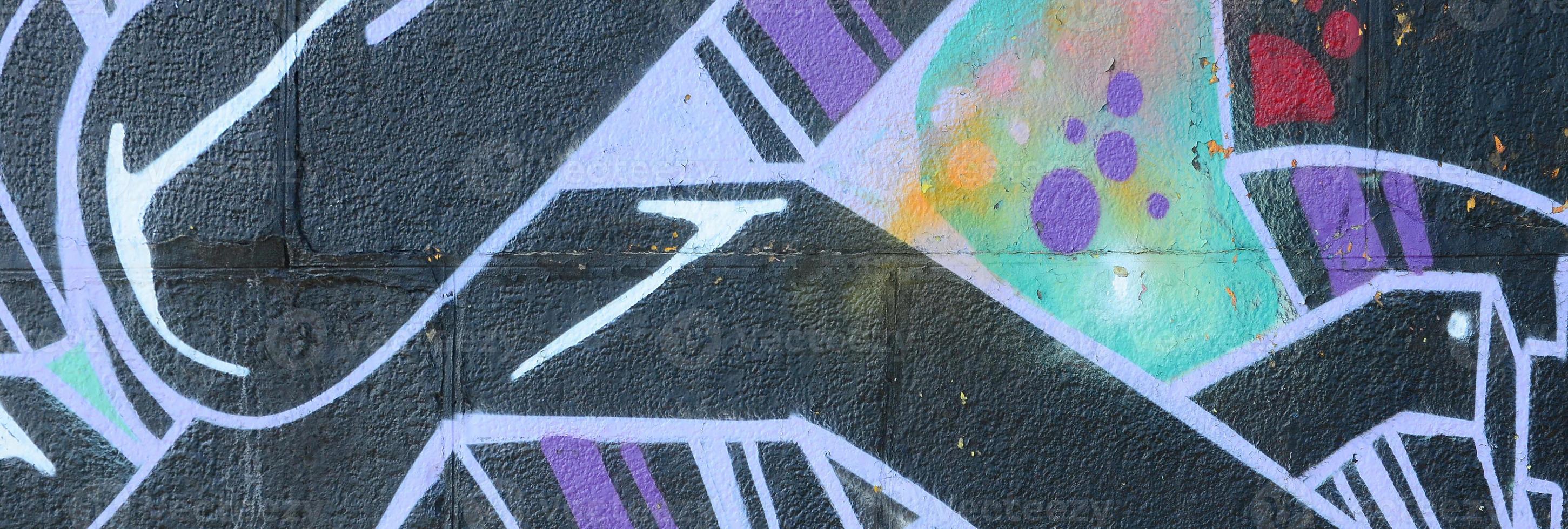 Fragment of graffiti drawings. The old wall decorated with paint stains in the style of street art culture. Colored background texture photo