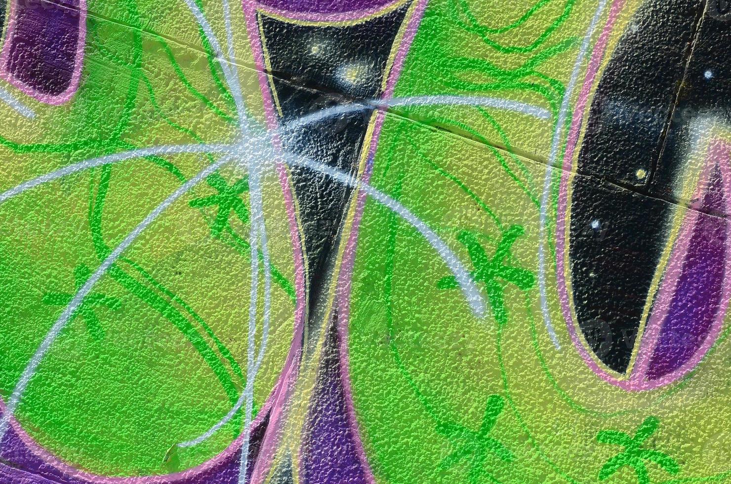 Fragment of graffiti drawings. The old wall decorated with paint stains in the style of street art culture. Colored background texture in green tones photo