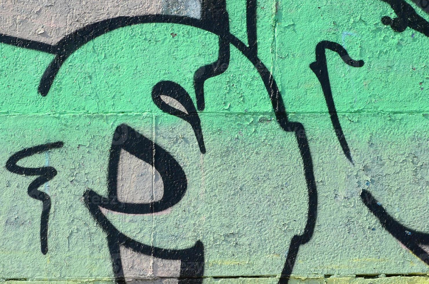 Fragment of graffiti drawings. The old wall decorated with paint stains in the style of street art culture. Colored background texture in green tones photo