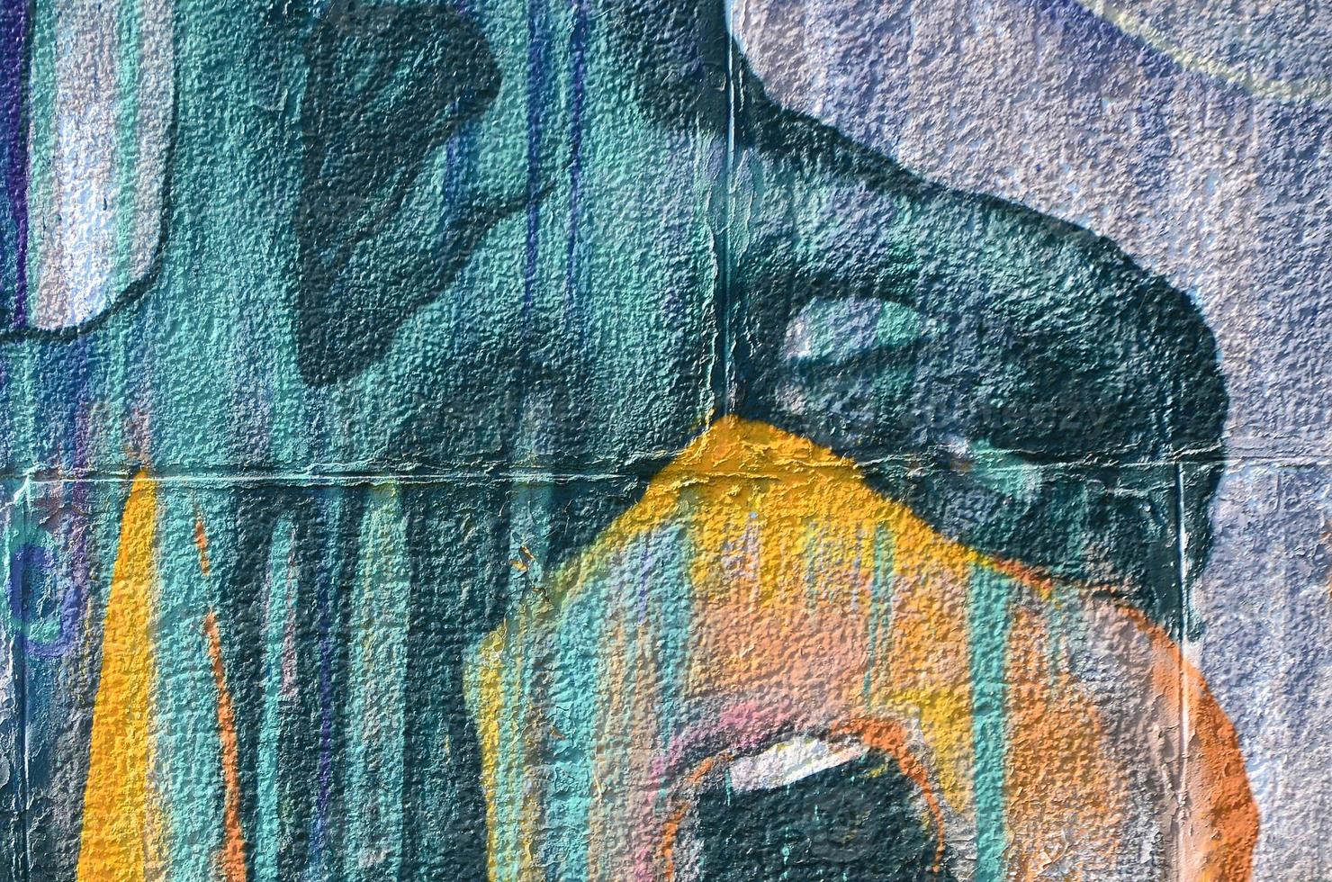 Fragment of graffiti drawings. The old wall decorated with paint stains in the style of street art culture. Colored background texture in warm tones photo