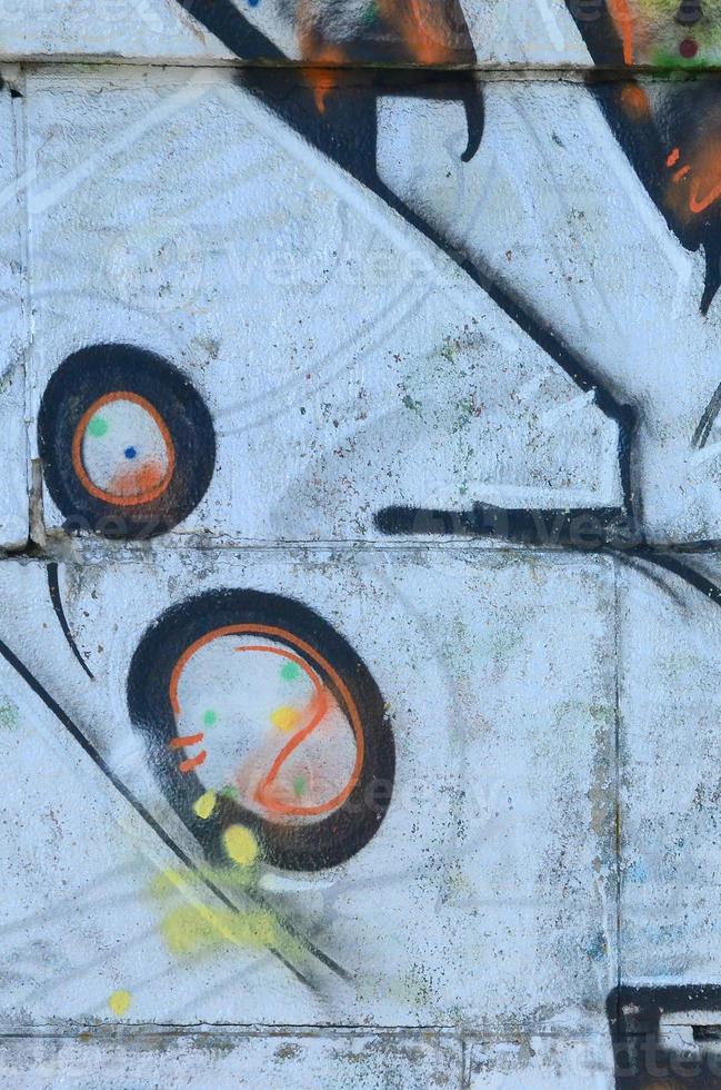 Fragment of graffiti drawings. The old wall decorated with paint stains in the style of street art culture. Colored background texture photo