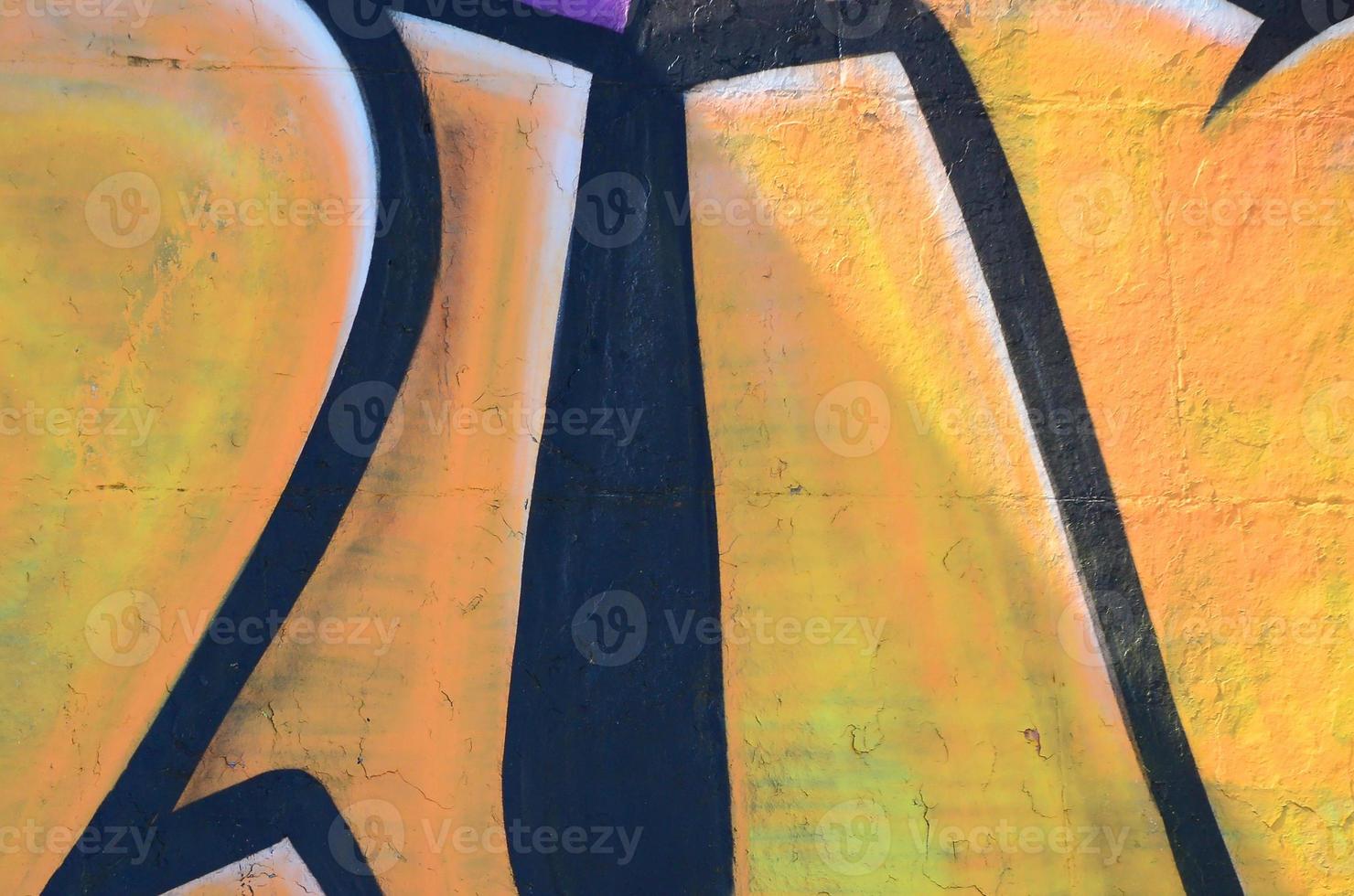 Fragment of graffiti drawings. The old wall decorated with paint stains in the style of street art culture. Colored background texture in warm tones photo