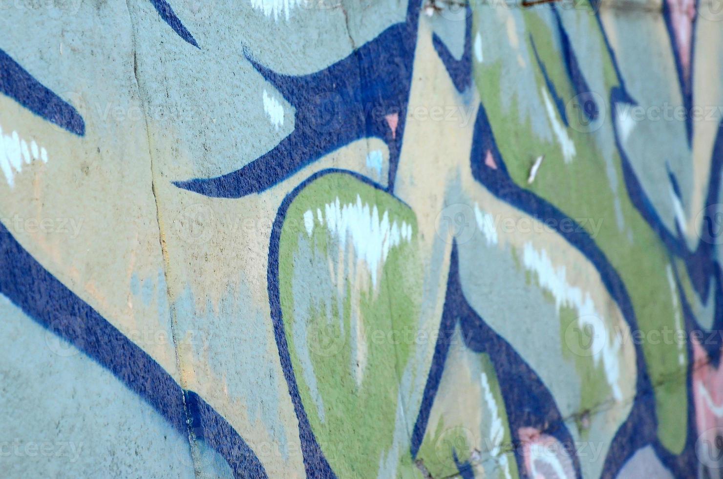 fragmento de dibujos de graffiti. la antigua muralla decorada con manchas de pintura al estilo de la cultura del arte callejero. textura de fondo coloreada en tonos verdes foto