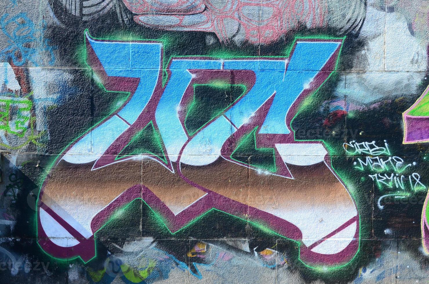 Fragment of graffiti drawings. The old wall decorated with paint stains in the style of street art culture. Multicolored background texture photo