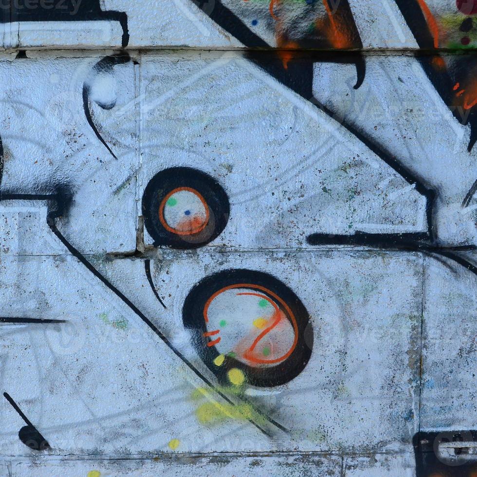 Fragment of graffiti drawings. The old wall decorated with paint stains in the style of street art culture. Colored background texture photo