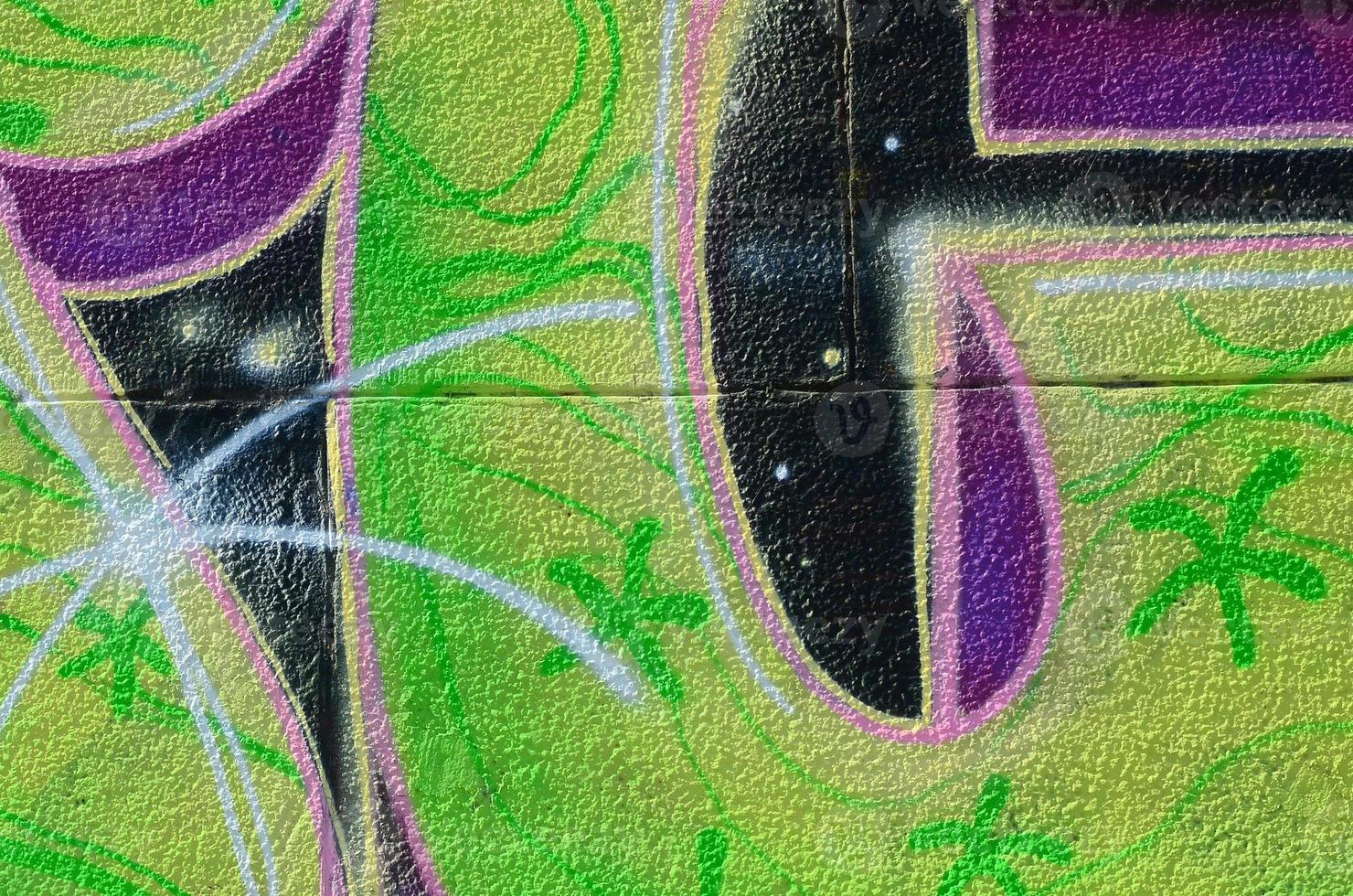 Fragment of graffiti drawings. The old wall decorated with paint stains in the style of street art culture. Colored background texture in green tones photo