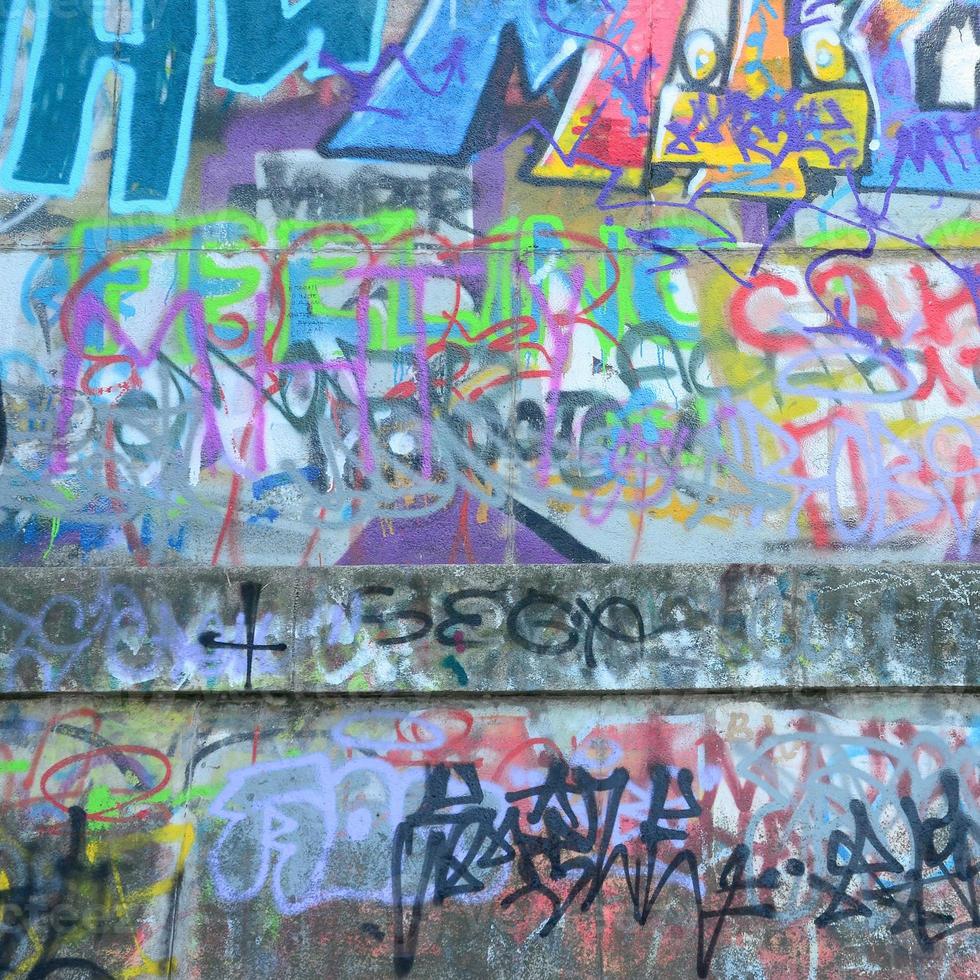 Fragment of graffiti tags. The old wall is spoiled with paint stains in the style of street art culture photo
