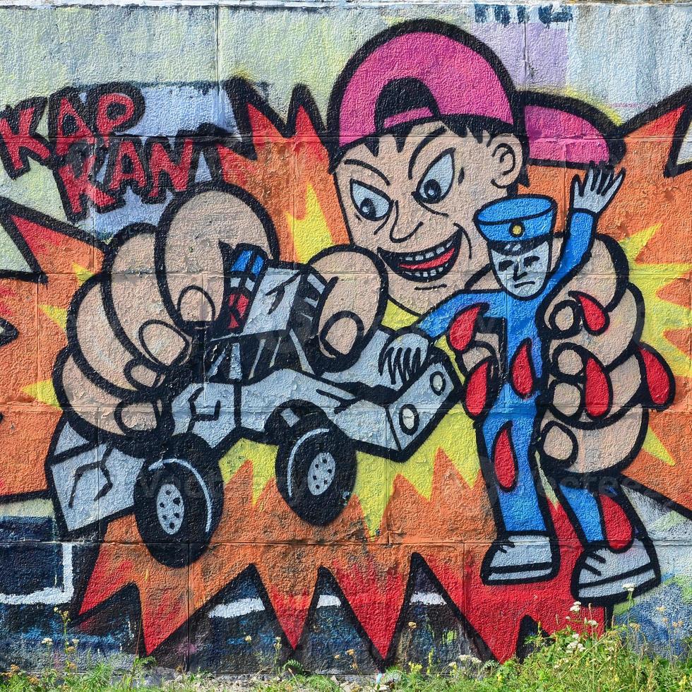 Fragment of graffiti drawings. The old wall decorated with paint stains in the style of street art culture. Child breaks police toys photo