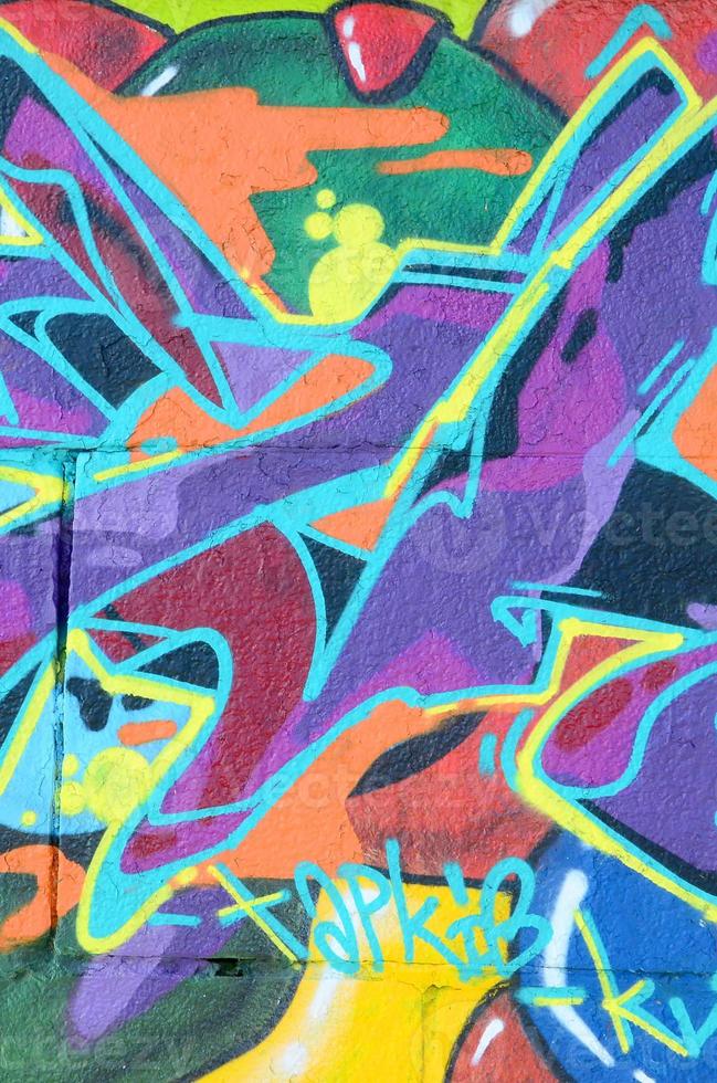 Fragment of graffiti drawings. The old wall decorated with paint stains in the style of street art culture. Multicolored background texture photo