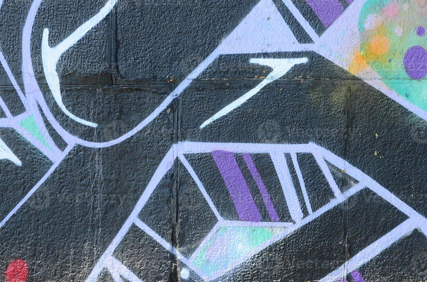 Fragment of graffiti drawings. The old wall decorated with paint stains in the style of street art culture. Colored background texture photo