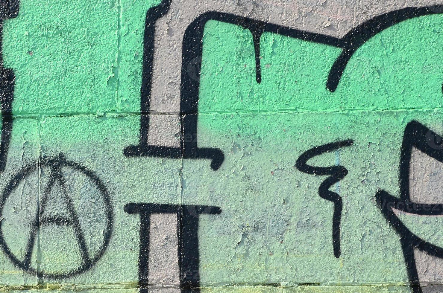 Fragment of graffiti drawings. The old wall decorated with paint stains in the style of street art culture. Colored background texture in green tones photo