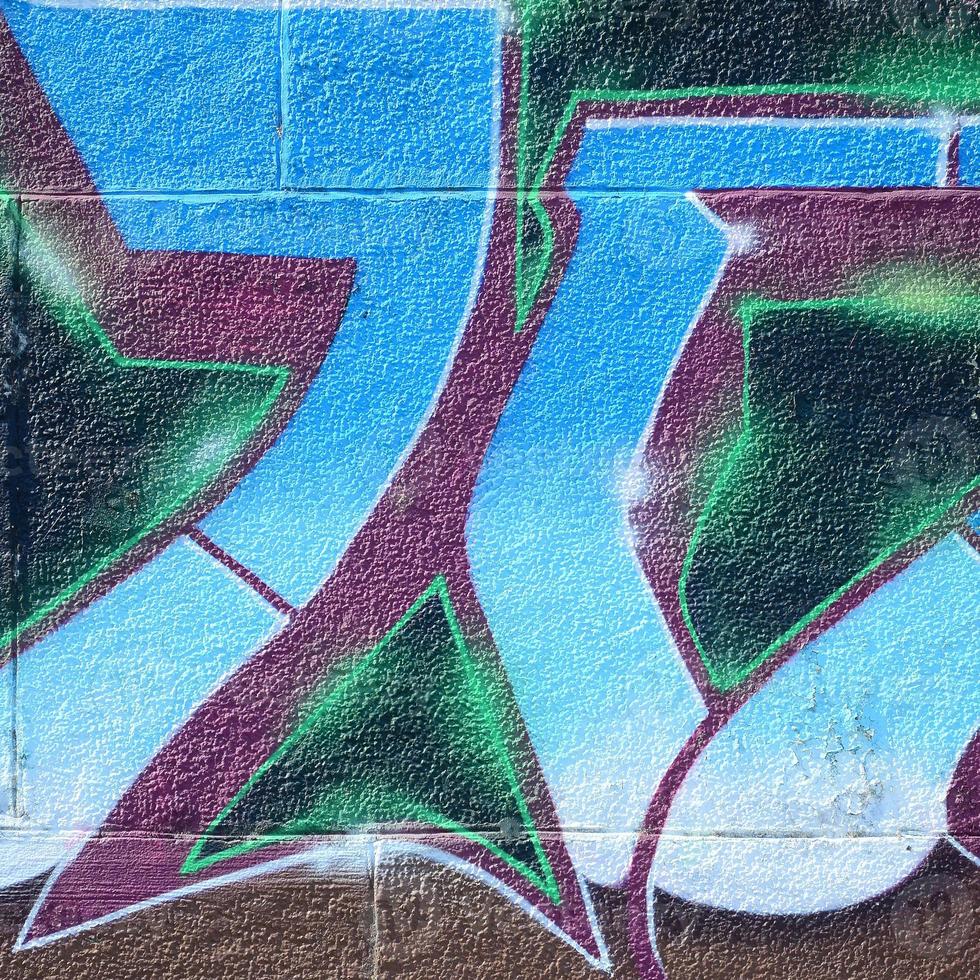 Fragment of graffiti drawings. The old wall decorated with paint stains in the style of street art culture. Colored background texture in cold tones photo