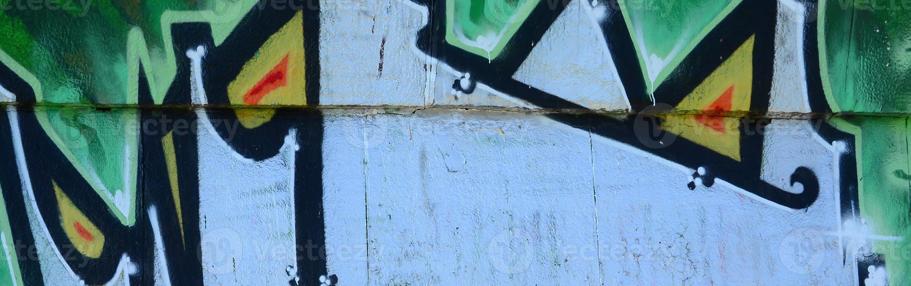 Fragment of graffiti drawings. The old wall decorated with paint stains in the style of street art culture. Colored background texture in green tones photo