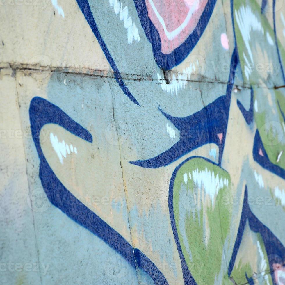 fragmento de dibujos de graffiti. la antigua muralla decorada con manchas de pintura al estilo de la cultura del arte callejero. textura de fondo coloreada en tonos verdes foto