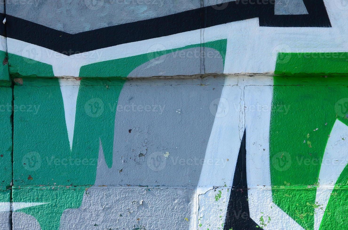 Fragment of graffiti drawings. The old wall decorated with paint stains in the style of street art culture. Colored background texture in green tones photo