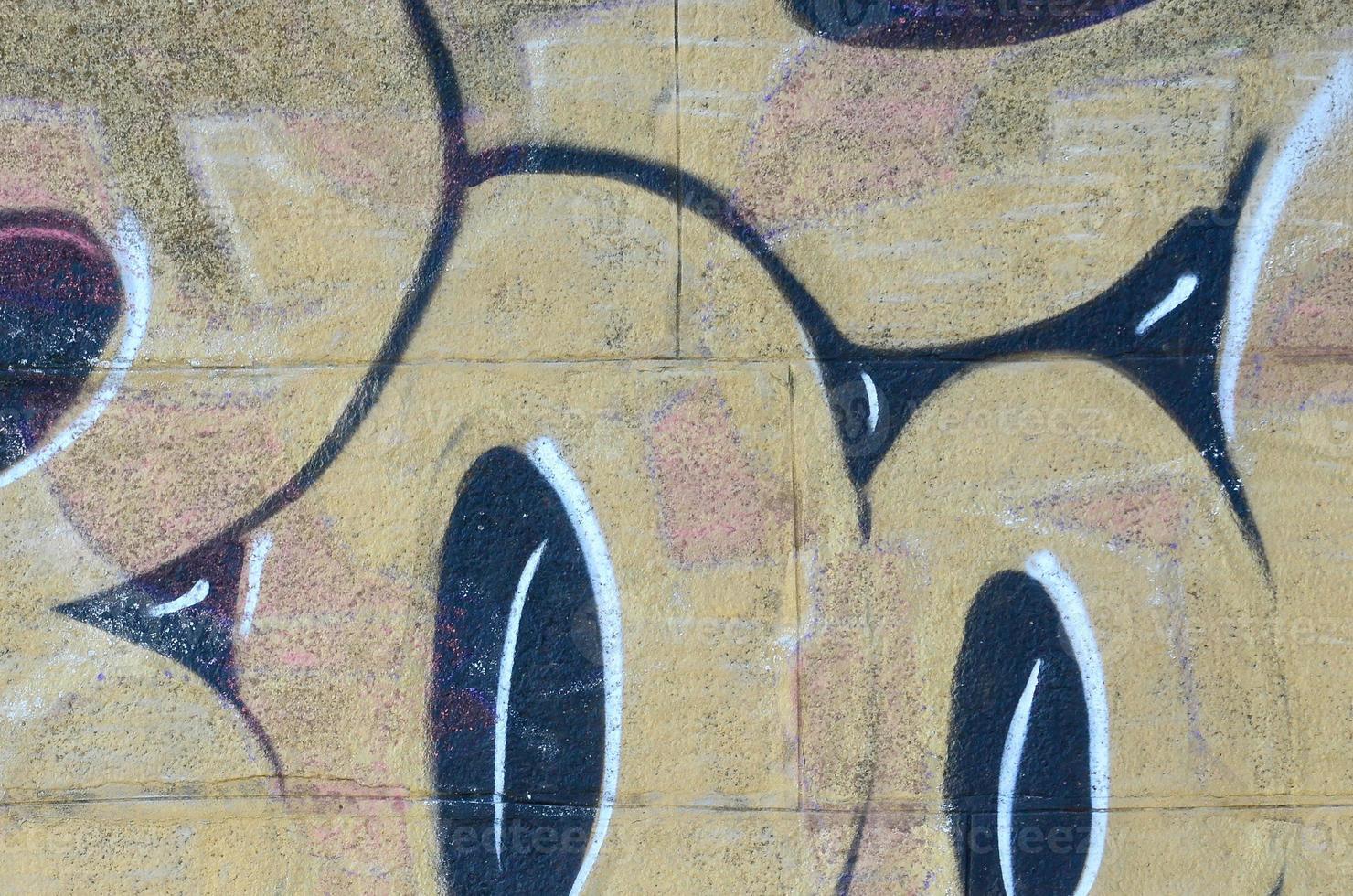 Fragment of graffiti drawings. The old wall decorated with paint stains in the style of street art culture. Colored background texture in warm tones photo