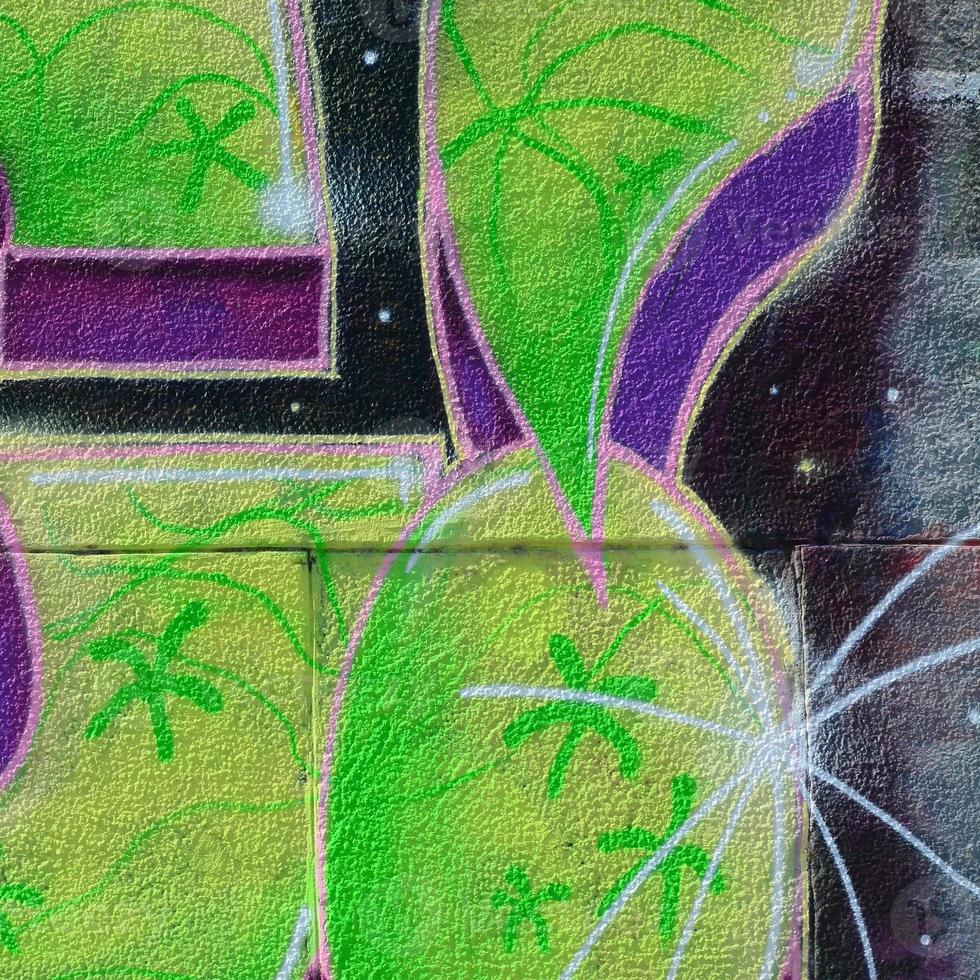 Fragment of graffiti drawings. The old wall decorated with paint stains in the style of street art culture. Colored background texture in green tones photo