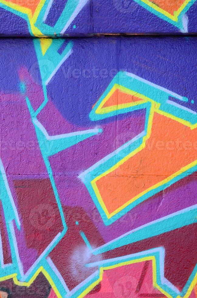 Fragment of graffiti drawings. The old wall decorated with paint stains in the style of street art culture. Colored background texture in purple tones photo