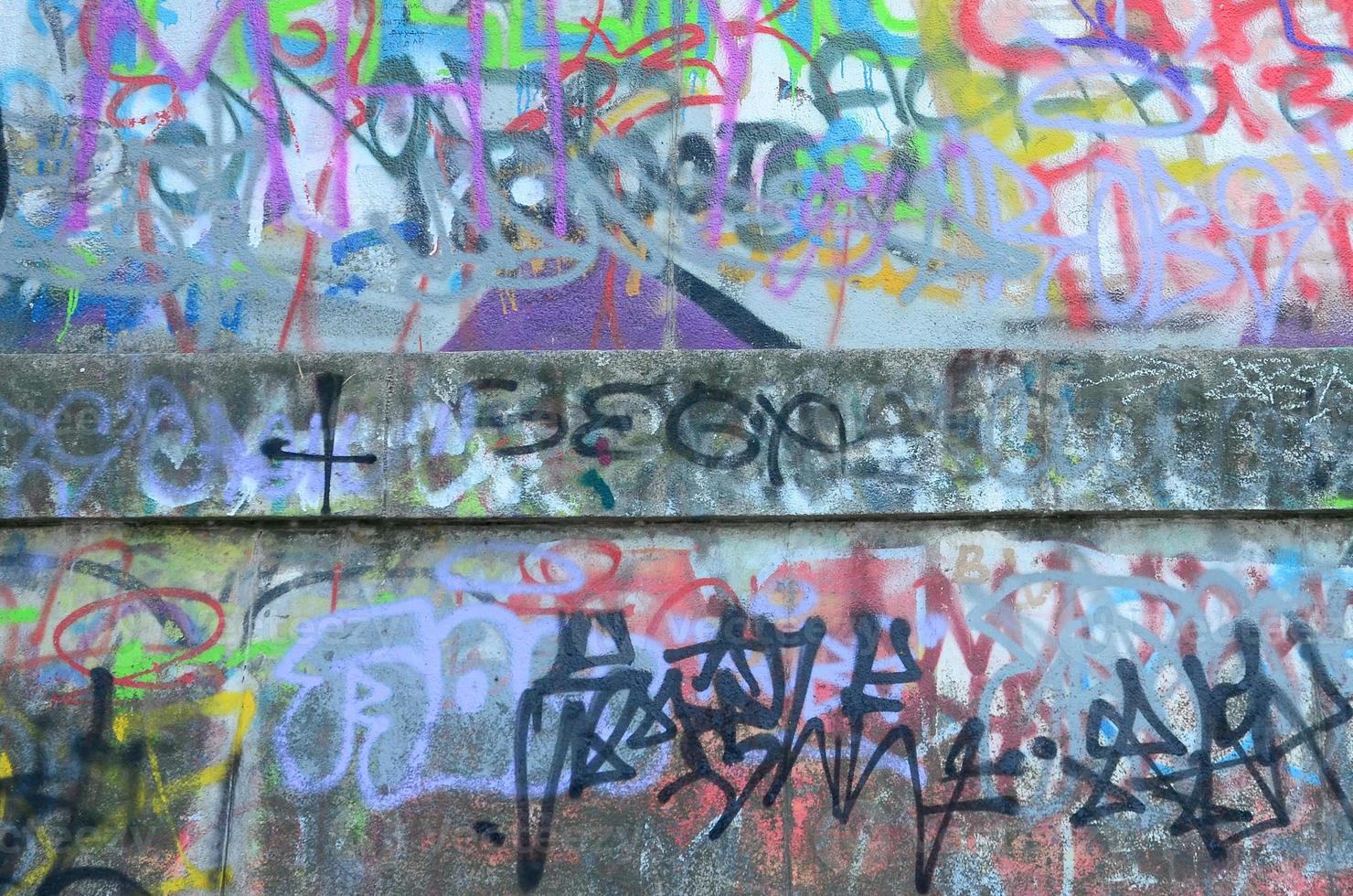 Fragment of graffiti tags. The old wall is spoiled with paint stains in the style of street art culture photo