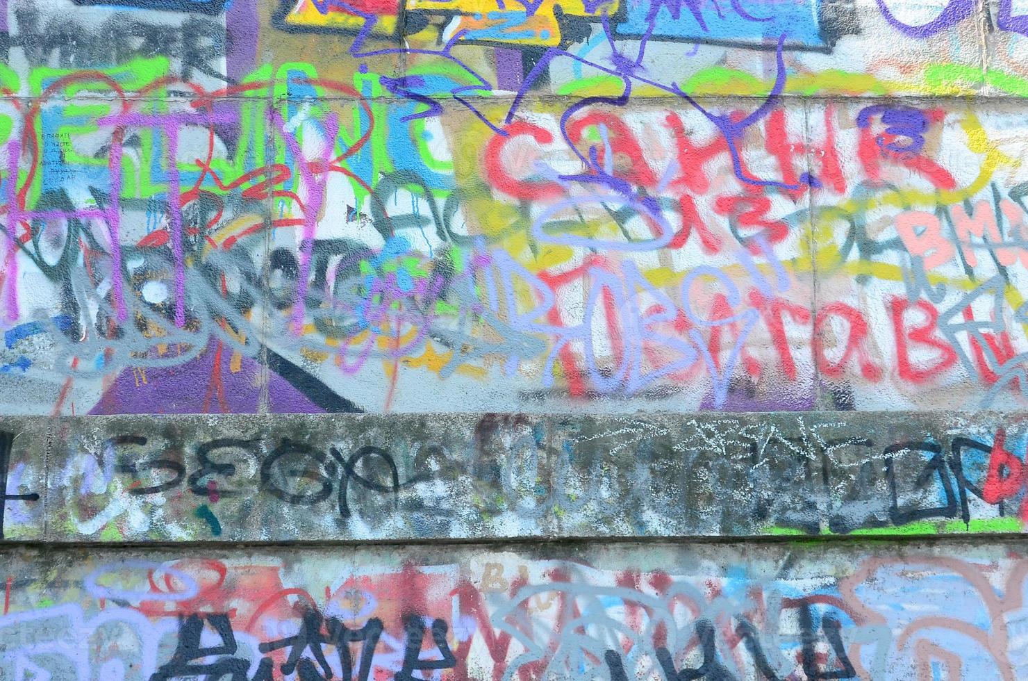 Fragment of graffiti tags. The old wall is spoiled with paint stains in the style of street art culture photo