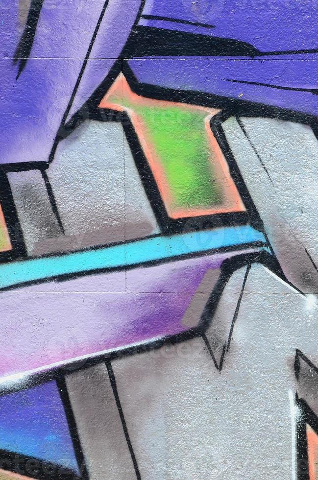 fragmento de dibujos de graffiti. la antigua muralla decorada con manchas de pintura al estilo de la cultura del arte callejero. textura de fondo coloreada en tonos morados foto