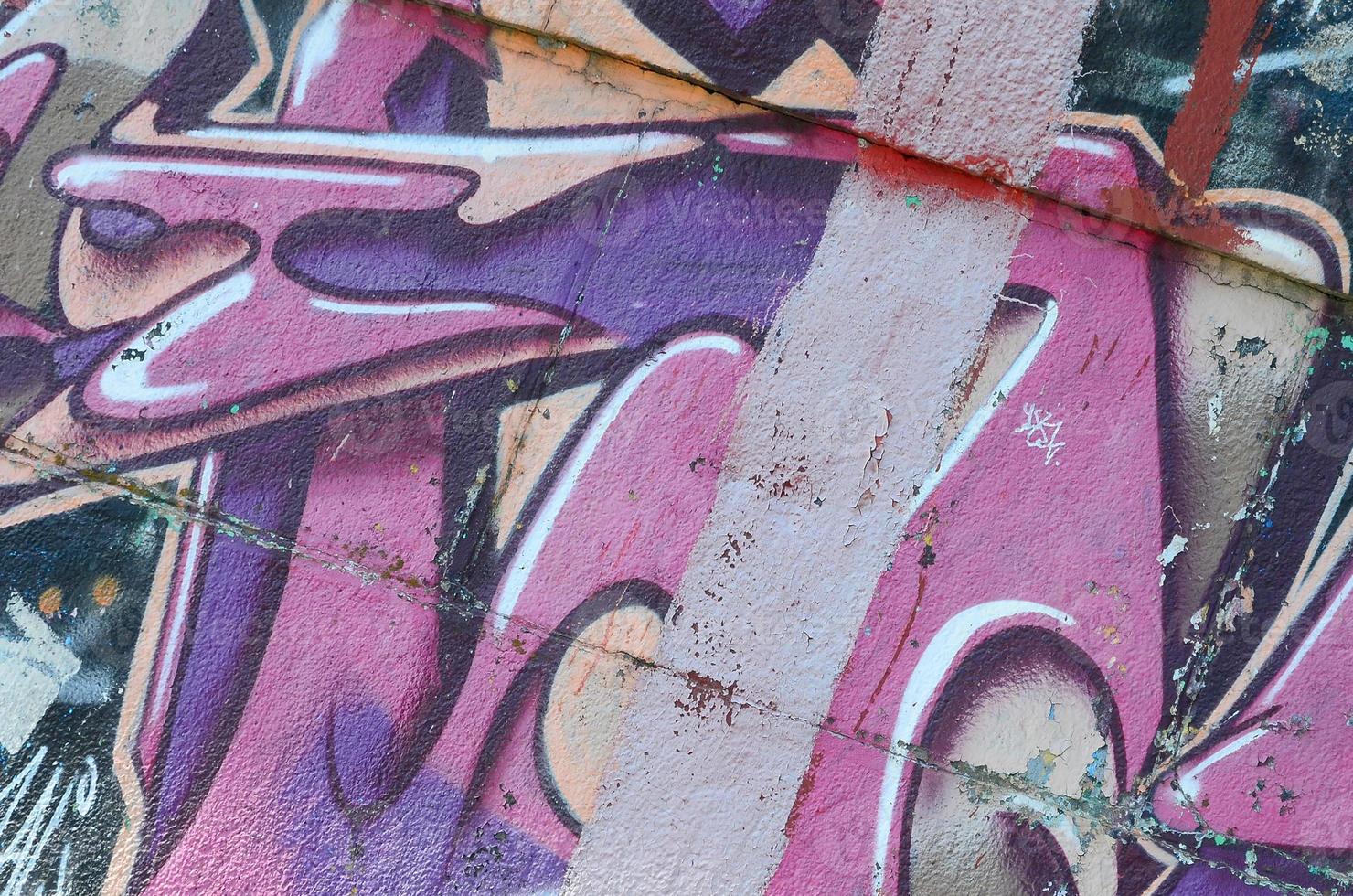 Fragment of graffiti drawings. The old wall decorated with paint stains in the style of street art culture. Colored background texture in purple tones photo