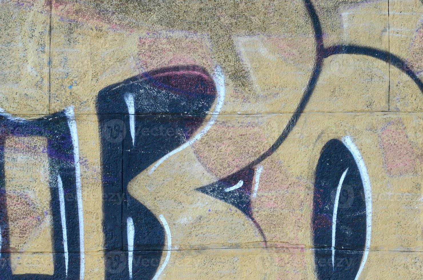 Fragment of graffiti drawings. The old wall decorated with paint stains in the style of street art culture. Colored background texture in warm tones photo