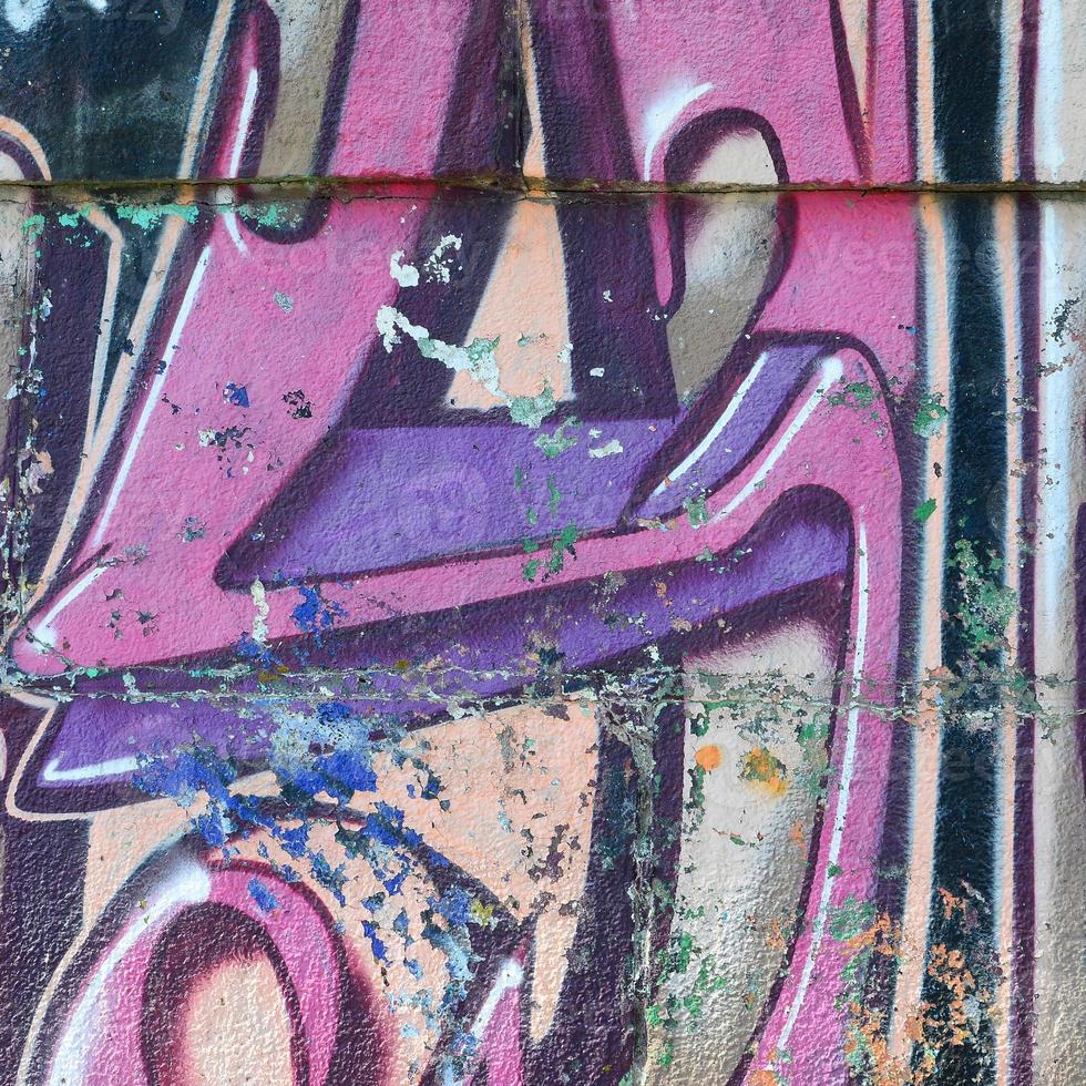 Fragment of graffiti drawings. The old wall decorated with paint stains in the style of street art culture. Colored background texture in purple tones photo
