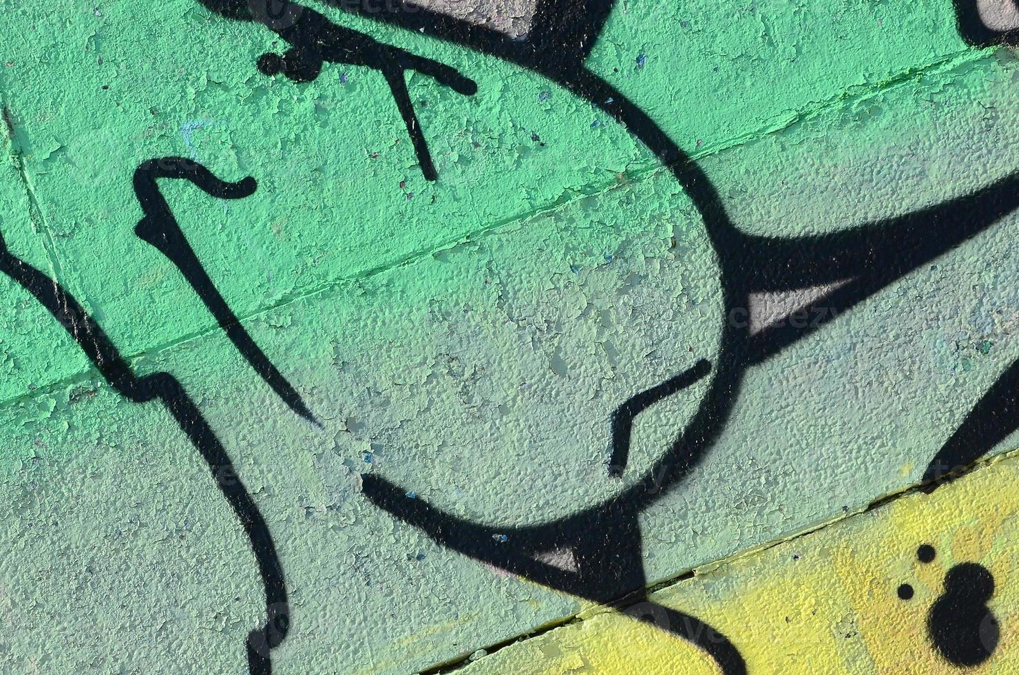 Fragment of graffiti drawings. The old wall decorated with paint stains in the style of street art culture. Colored background texture in green tones photo