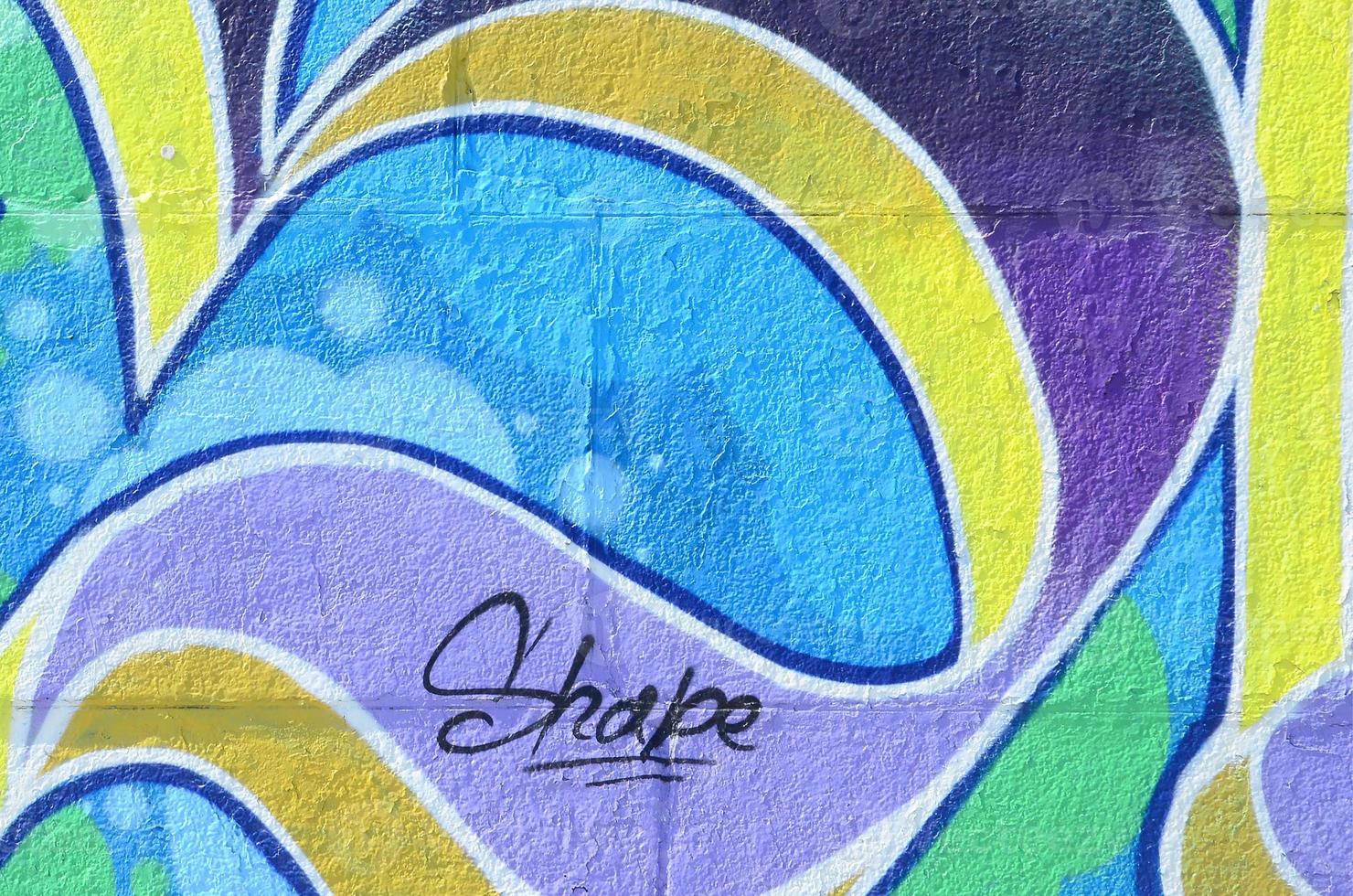 Fragment of graffiti drawings. The old wall decorated with paint stains in the style of street art culture. Colored background texture in cold tones photo