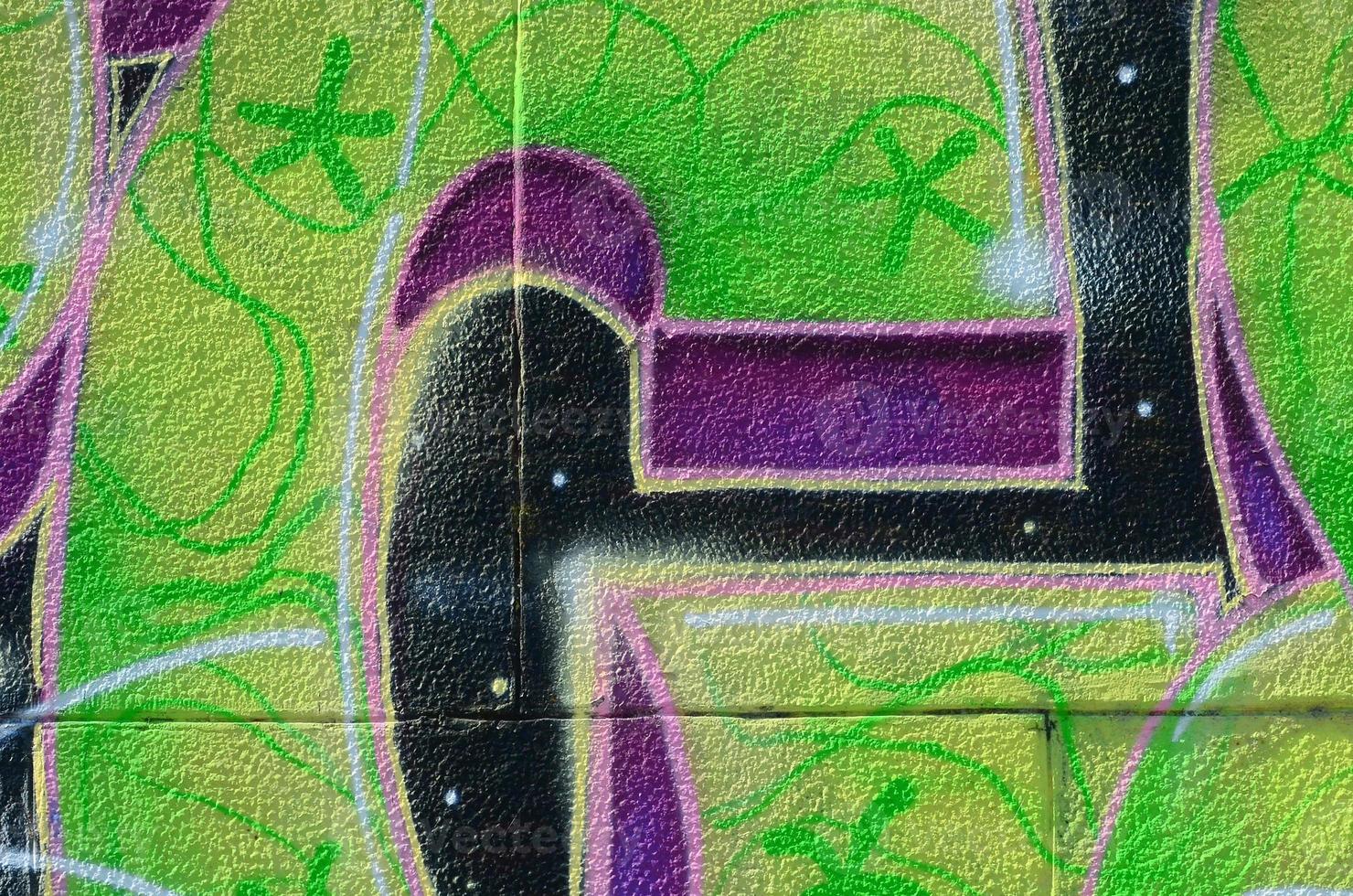 Fragment of graffiti drawings. The old wall decorated with paint stains in the style of street art culture. Colored background texture in green tones photo