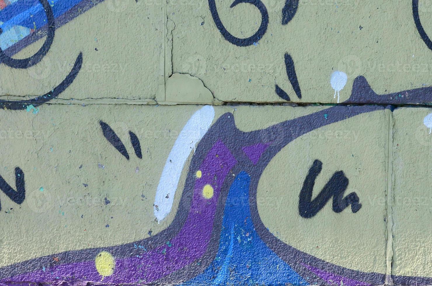 Fragment of graffiti drawings. The old wall decorated with paint stains in the style of street art culture. Colored background texture in warm tones photo
