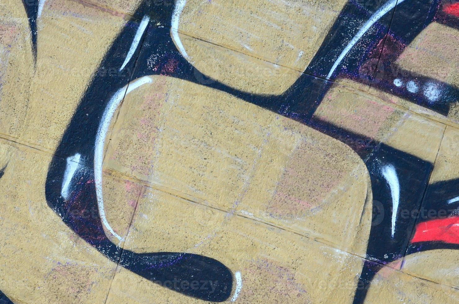 Fragment of graffiti drawings. The old wall decorated with paint stains in the style of street art culture. Colored background texture in warm tones photo