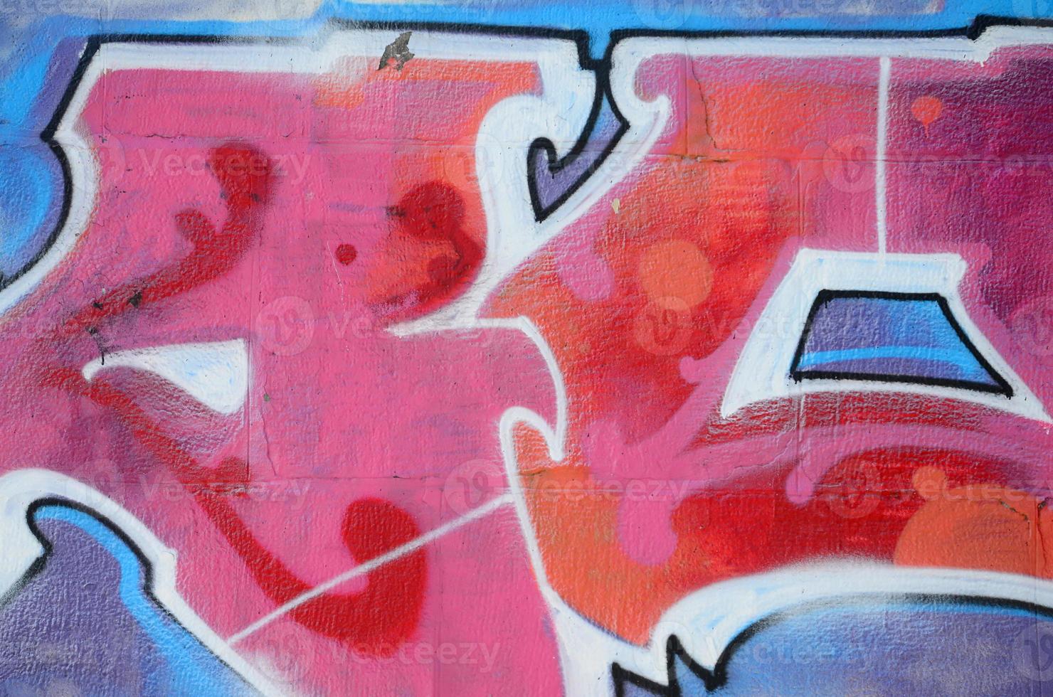 Fragment of graffiti drawings. The old wall decorated with paint stains in the style of street art culture. Colored background texture in warm tones photo