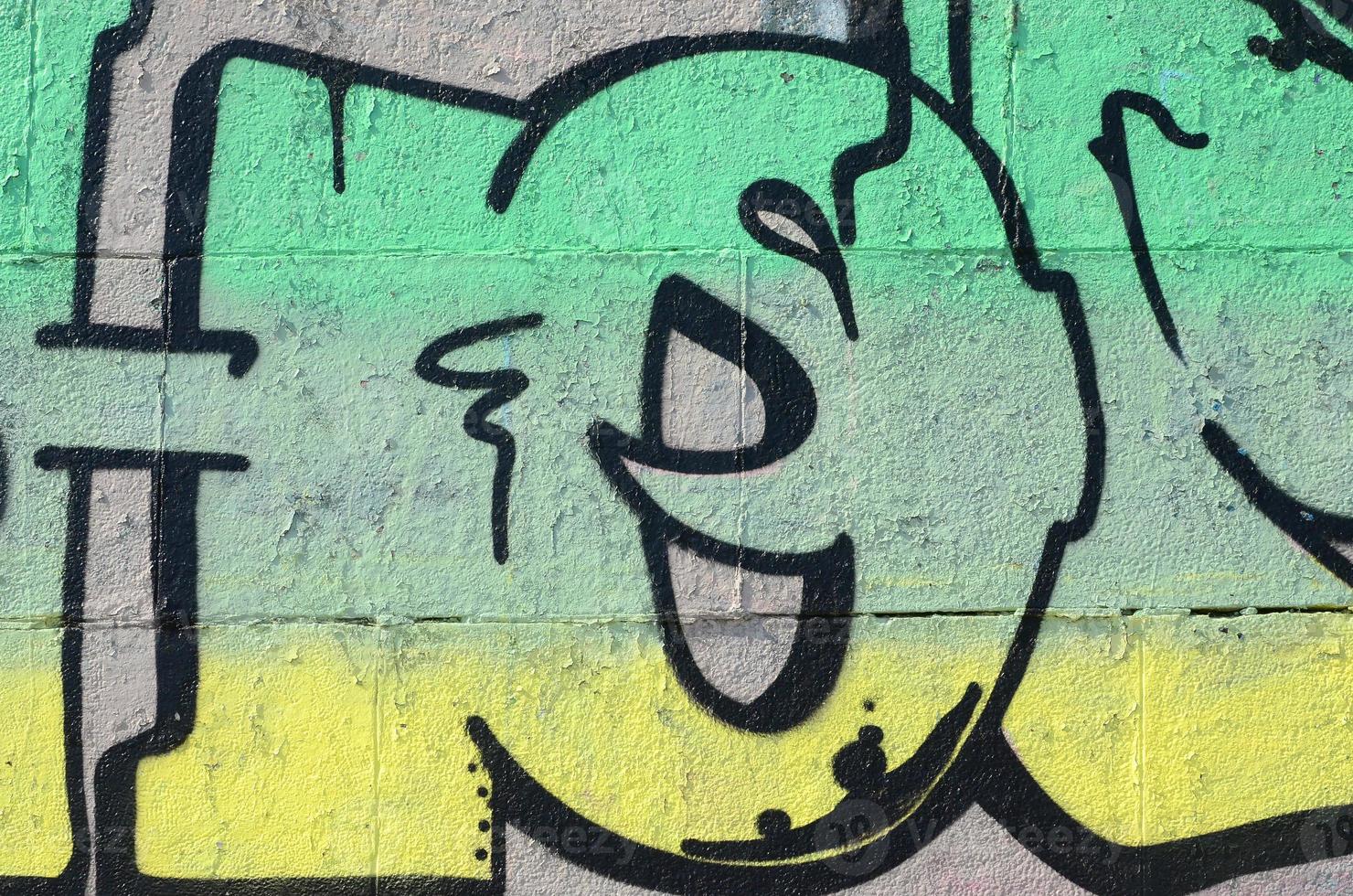 fragmento de dibujos de graffiti. la antigua muralla decorada con manchas de pintura al estilo de la cultura del arte callejero. textura de fondo coloreada en tonos verdes foto