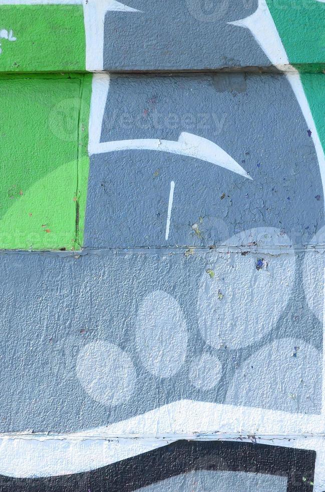 Fragment of graffiti drawings. The old wall decorated with paint stains in the style of street art culture. Colored background texture in green tones photo