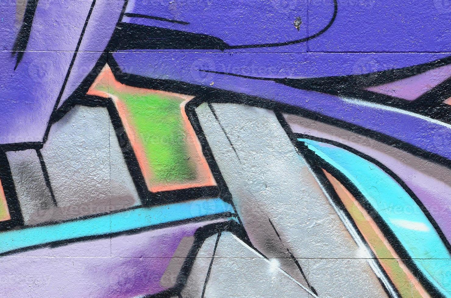 Fragment of graffiti drawings. The old wall decorated with paint stains in the style of street art culture. Colored background texture in purple tones photo