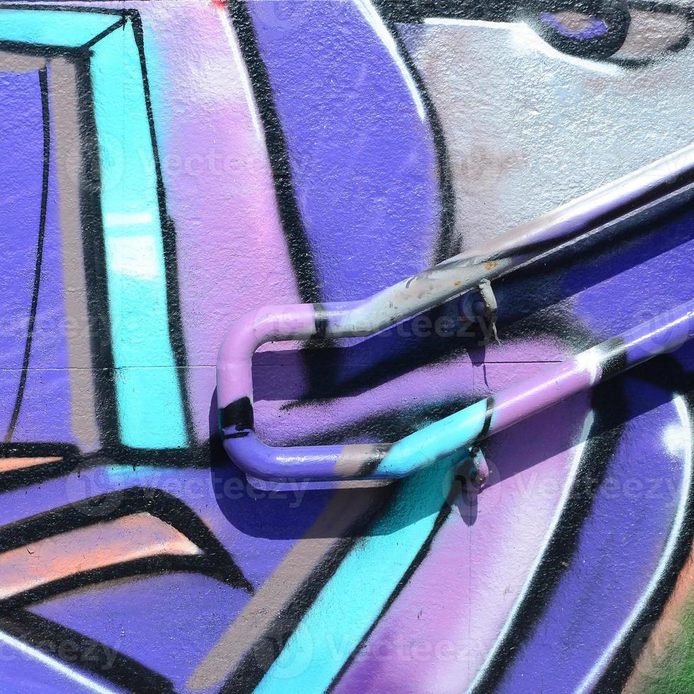 Fragment of graffiti drawings. The old wall decorated with paint stains in the style of street art culture. Colored background texture in purple tones photo