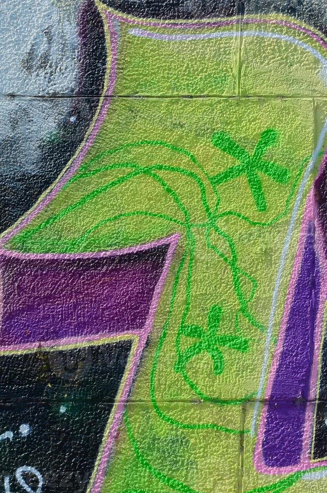 Fragment of graffiti drawings. The old wall decorated with paint stains in the style of street art culture. Colored background texture in green tones photo